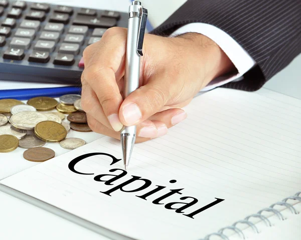 Hand pointing to Capital word on the paper — Stock Photo, Image