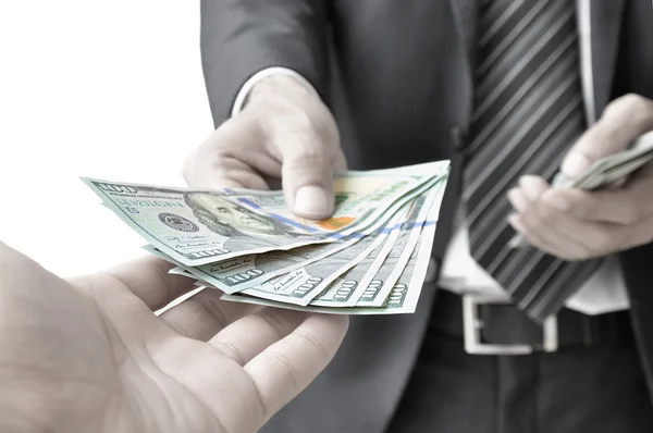 Hand giving money to another person — Stock Photo, Image