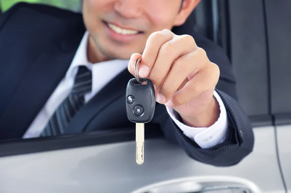 Üzletember mutatja egy autó kulcs — Stock Fotó