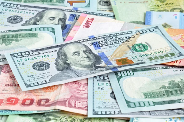 Geld in mehreren Währungen mit 100 USD-Schein an der Spitze — Stockfoto