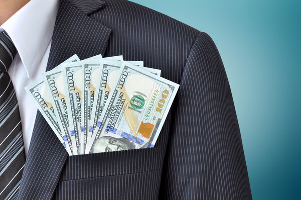 Dollar banknotes in pocket of businessman's suit