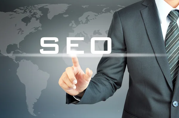 Businessman hand touching SEO sign Stock Picture