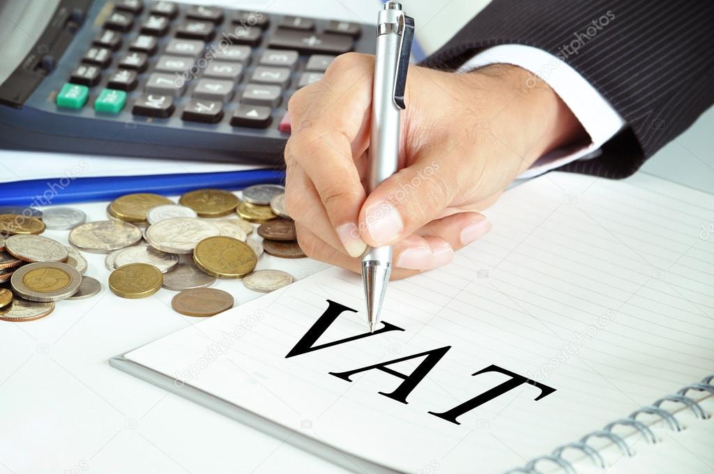 Hand pointing to VAT word on paper