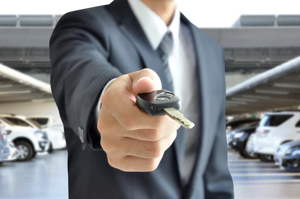 Empresário mão dando uma chave de carro - carro venda & conceito de negócio de aluguel — Fotografia de Stock