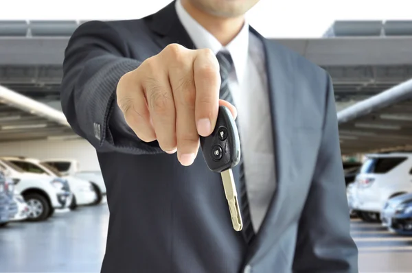 Empresario mano dando una llave del coche - venta de coches & concepto de negocio de alquiler —  Fotos de Stock