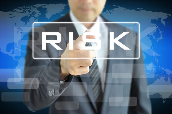 Empresario mano señalando a la palabra de riesgo en la pantalla virtual — Foto de Stock