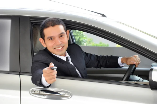 Homme d'affaires comme chauffeur donnant une clé de voiture — Photo