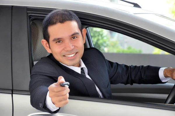 Empresario como conductor dando una llave de coche — Foto de Stock