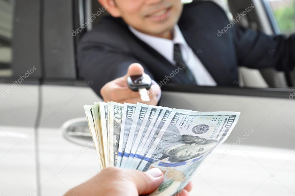 Businessman giving a car key exchanging with money — Stock Photo