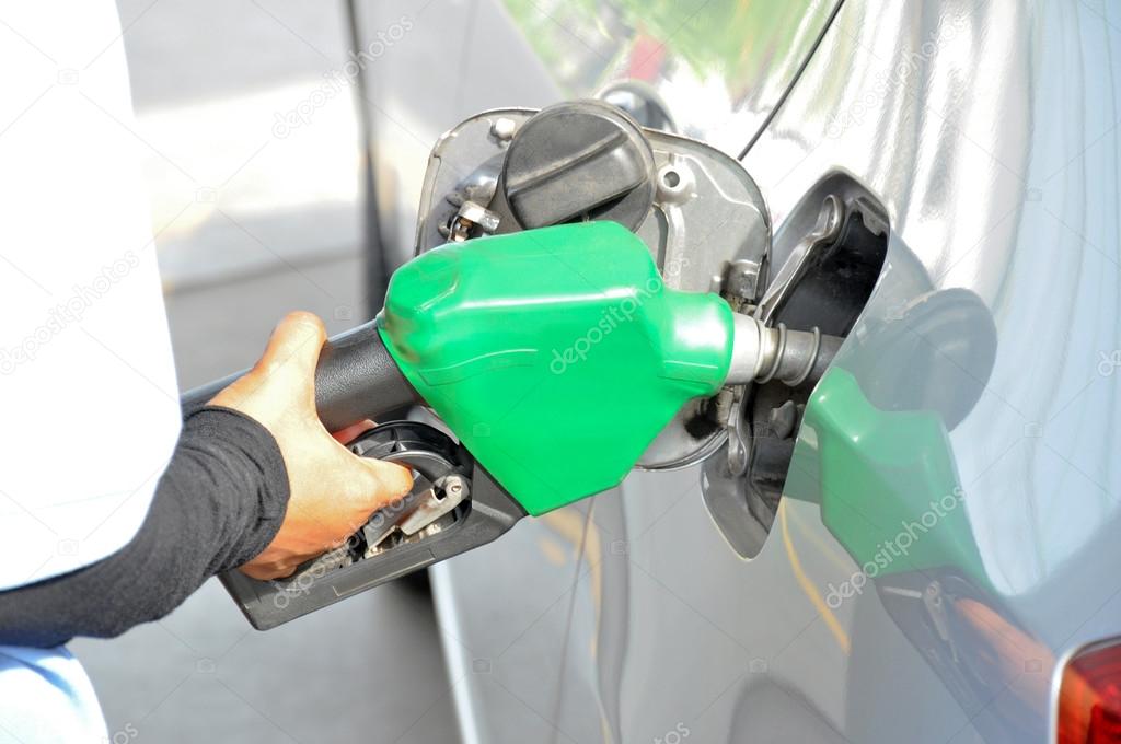 A man filling up the gas tank of a car