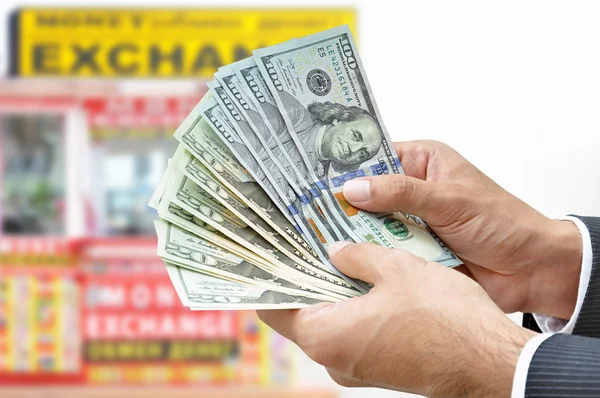 Hand holding US dollar banknotes - money exchange concept — Stockfoto