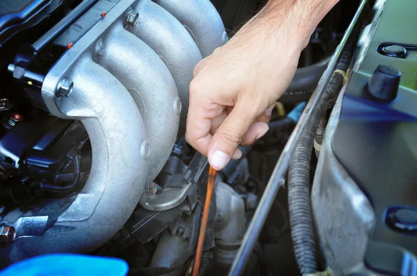 Mão puxando dipstick verificando o óleo do motor do carro — Fotografia de Stock