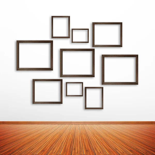 Wooden photo frames on white wall inside the room — Stock Photo, Image