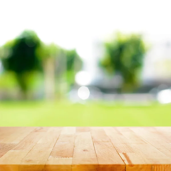 Dřevo stolu na abstraktní pozadí rozmazané zelené přírody — Stock fotografie