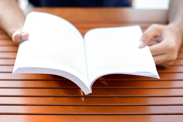 Otwarcie książki na stole - czytanie koncepcja ręce — Zdjęcie stockowe