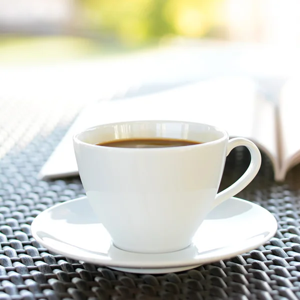 Tasse à café avec livre sur table en osier — Photo