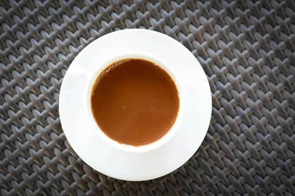 Чашка кави на коричневому плетеному столі — стокове фото