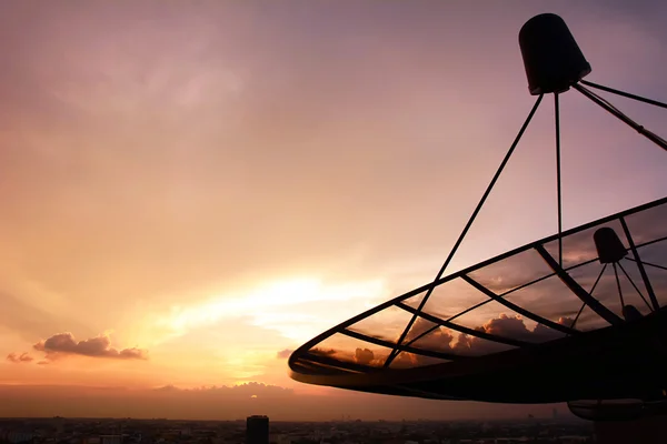 Silhueta antena parabólica no crepúsculo céu fundo — Fotografia de Stock