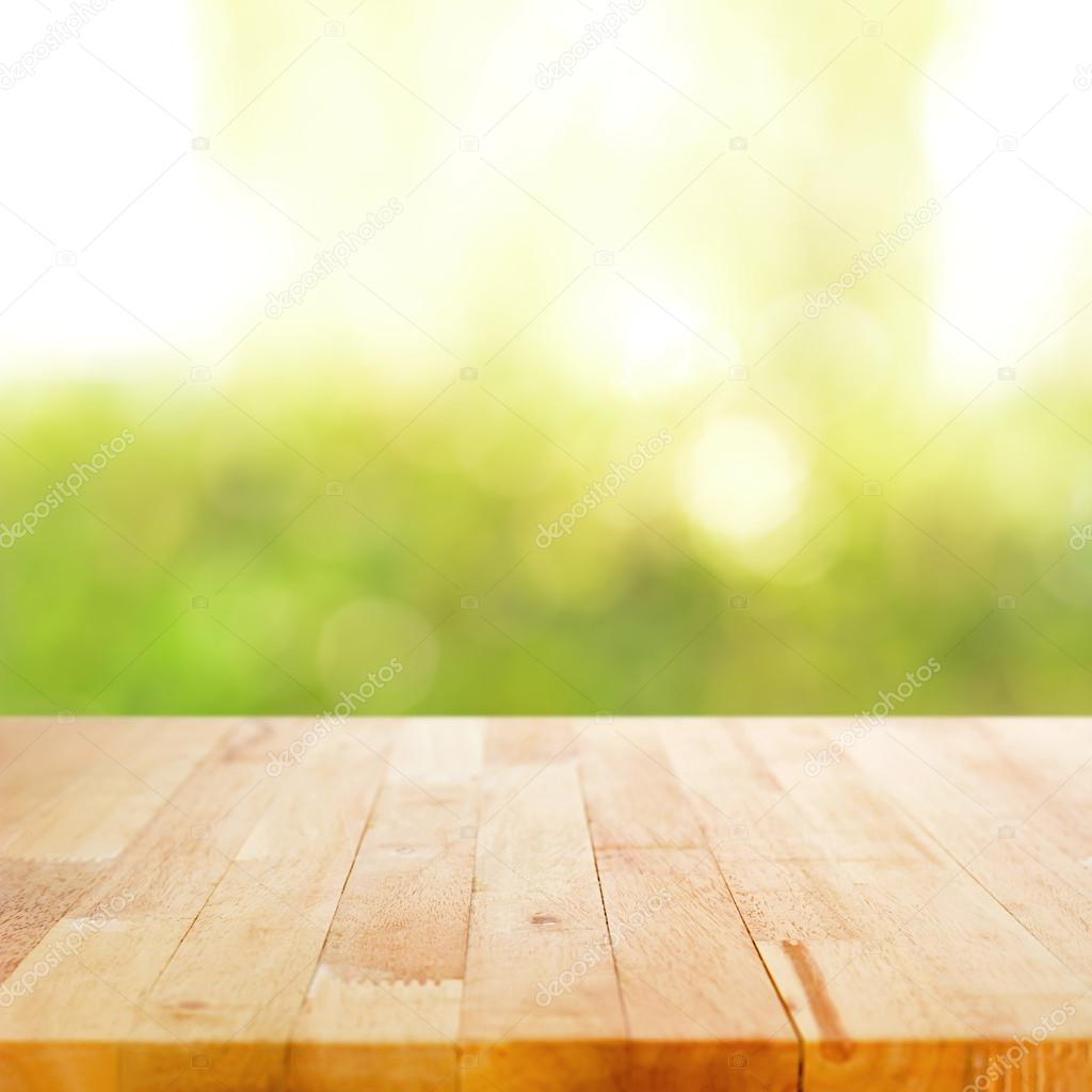 Wood table top on blurry green abstract background