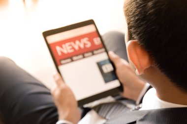 Tablet bilgisayar kullanılarak işadamı haber okuma