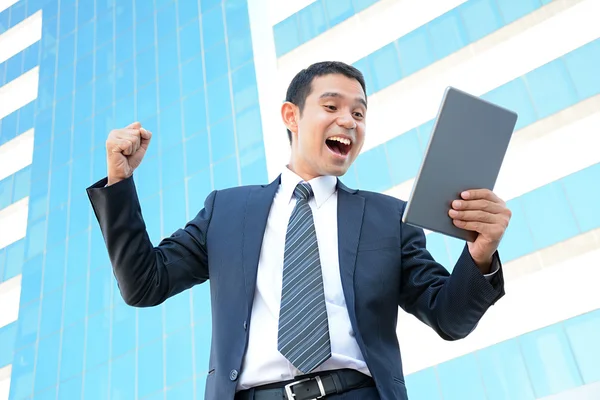 Empresario levantando el brazo mientras mira la tableta PC —  Fotos de Stock