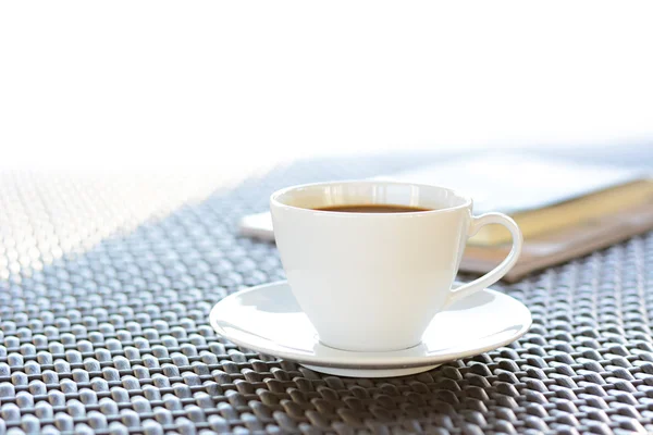 Tasse à café avec livre sur table en osier brun — Photo