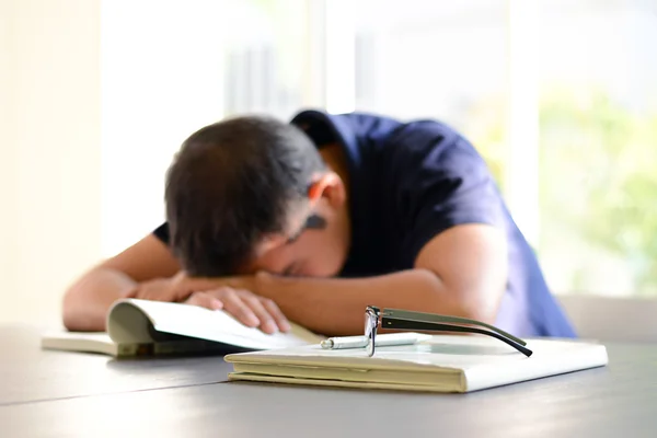 Young man sleeping on the table with book opened, weary & tired concept — Stock Photo, Image