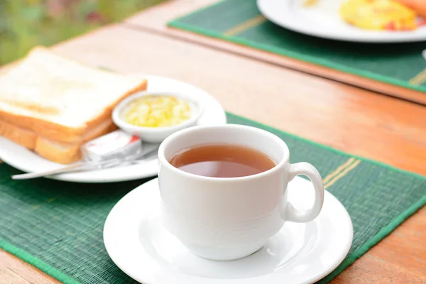 Forró tea, fehér csésze szeletelt kenyér a zöld szőnyeg — Stock Fotó