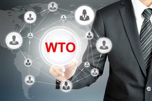 Uomo d'affari che punta sul OMC (Organizzazione mondiale del commercio) segno sullo schermo virtuale — Foto Stock