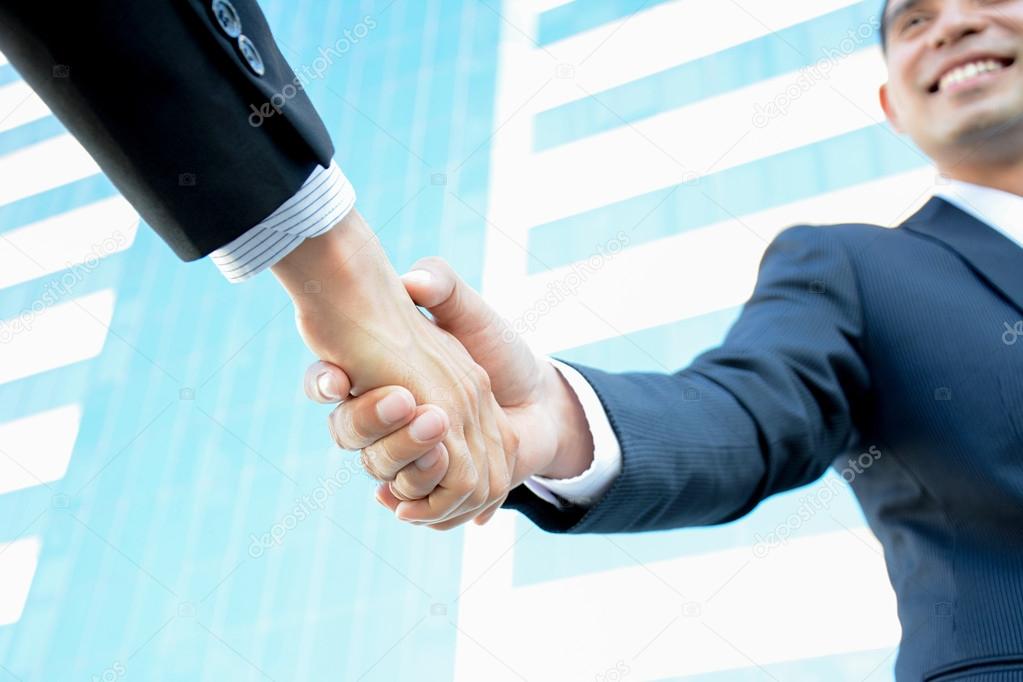 Handshake of businessmen with smiling face