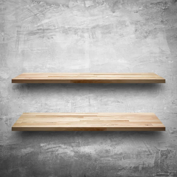 Empty wooden shelves on bare concrete wall background — Stock Photo, Image