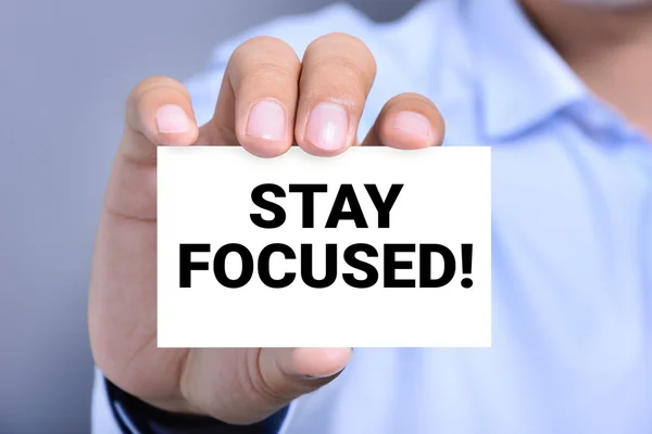 STAY FOCUSED! message on the card shown by a man — Stock Photo, Image