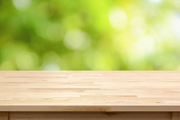 Holz Tischplatte auf Bokeh abstrakten grünen Hintergrund — Stockfoto