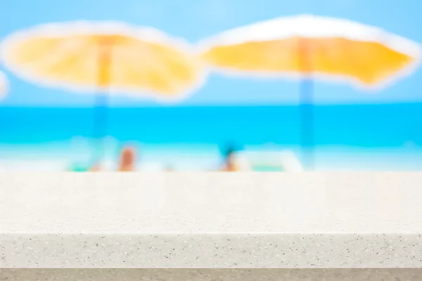 Arbeitsplatte aus weißem Stein auf verschwommenem Strand-Hintergrund — Stockfoto