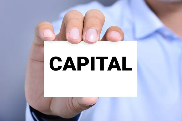 Kapital ordet på kortet visas av en man — Stockfoto