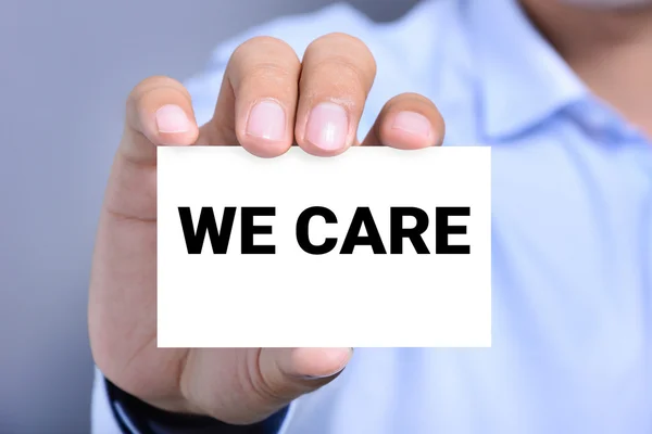 WE CARE, message on the card shown by a man — Stock Photo, Image