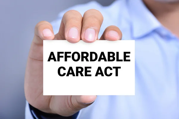 AFFORDABLE CARE ACT (or ACA) message on the card shown by a man — Stock Photo, Image
