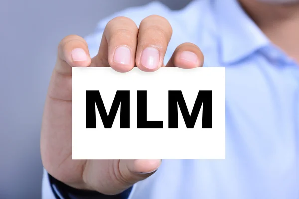 MLM písmena na kartou vystavenou ruka člověka — Stock fotografie