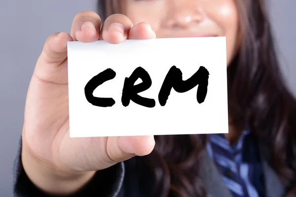 Cartas CRM (ou Customer Relationship Management) no cartão mostrado por uma empresária — Fotografia de Stock