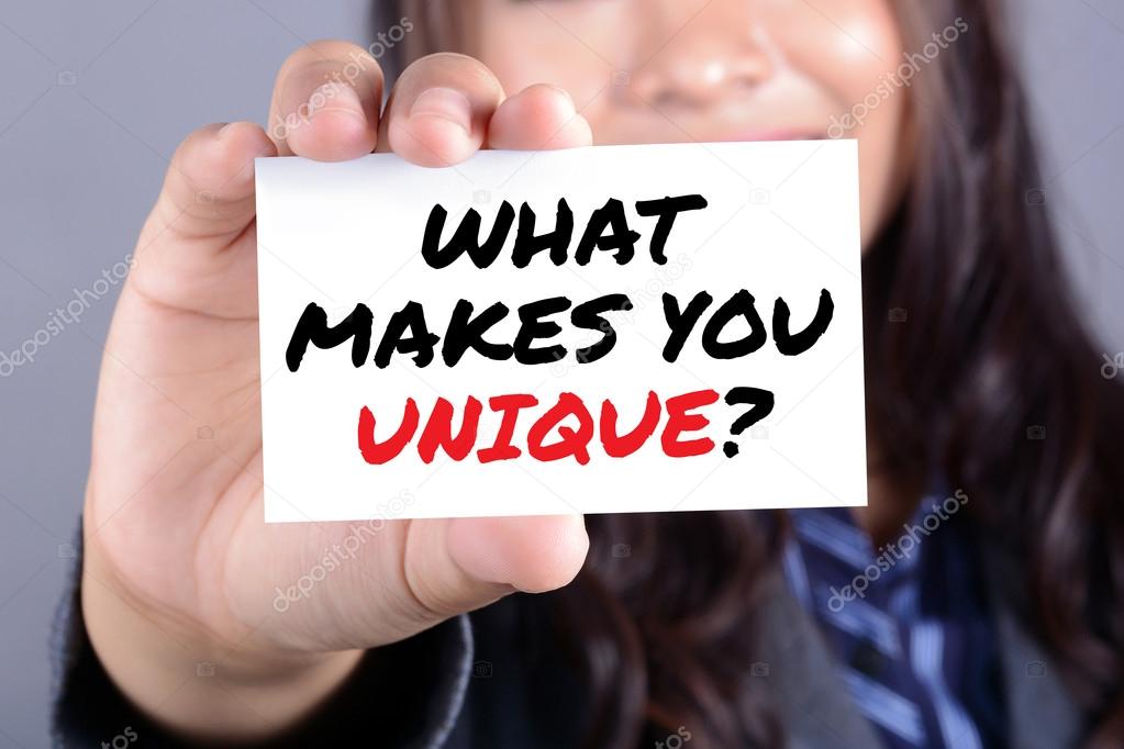 WHAT MAKES YOU UNIQUE?, message on the card shown by a businesswoman