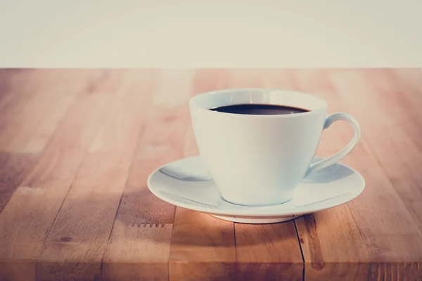 Xícara de café na mesa de madeira - tom vintage — Fotografia de Stock