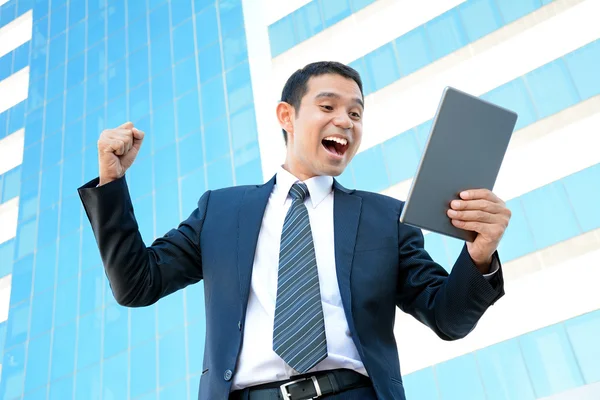 Empresario gritando y levantando el puño mientras mira la tableta PC —  Fotos de Stock