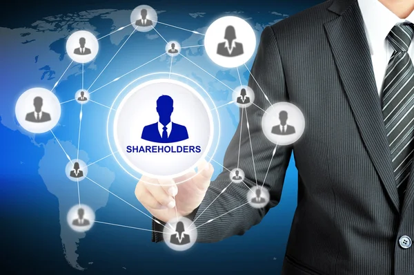 Businessman pointing on SHAREHOLDERS sign on virtual screen with people icons linked as network — Stock Photo, Image