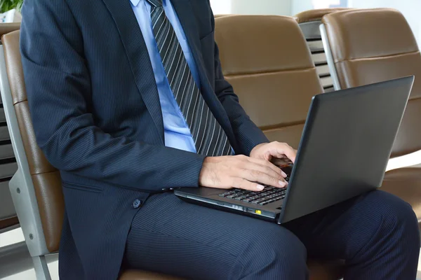 Empresario que usa computadora portátil o computadora portátil mientras está sentado en t —  Fotos de Stock