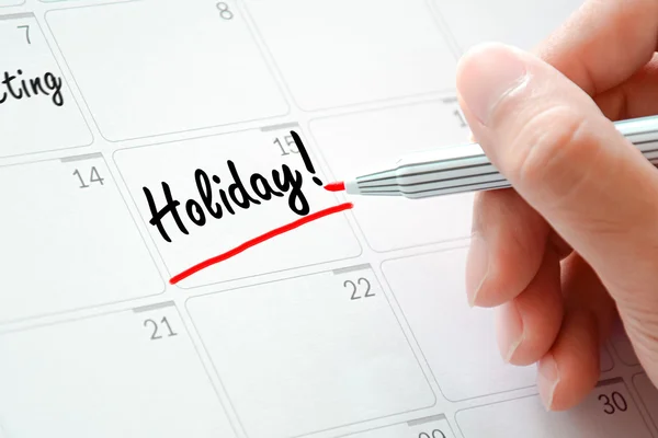 Testo festivo sul calendario (o sul desk planner) sottolineato con un pennarello rosso — Foto Stock