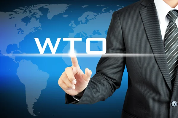 L'uomo d'affari punta mano al WTO (o Organizzazione Mondiale del Commercio) segno sullo schermo virtuale — Foto Stock