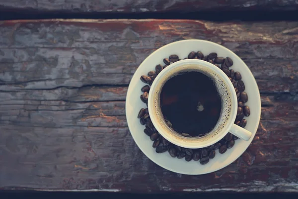 Café negro en la taza en la mesa de madera vieja, vista superior con espacio para copiar —  Fotos de Stock