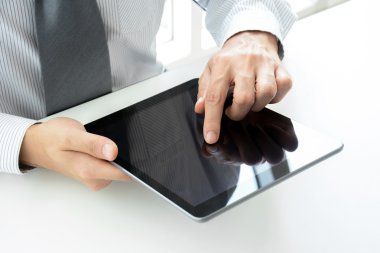 Tablet pc ekran dokunaklı bir elinizle masada kullanarak iş adamı