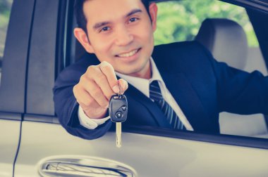 Asian businessman giving a car key