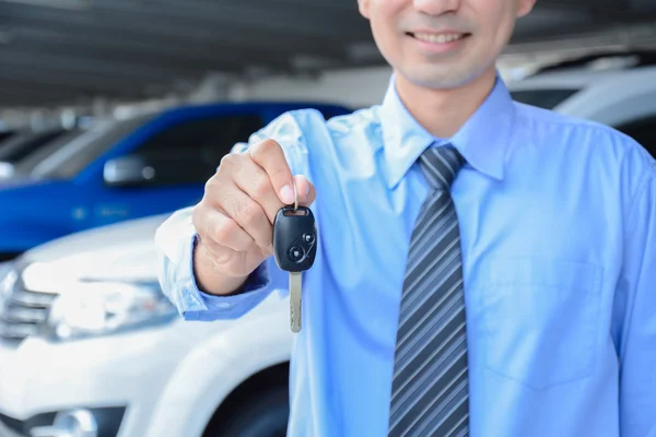 Businessman giving a car key - car sale, rental & insurance concepts — Stock Photo, Image